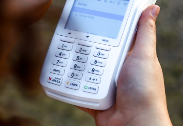 Mano sosteniendo una terminal de pago electrónico