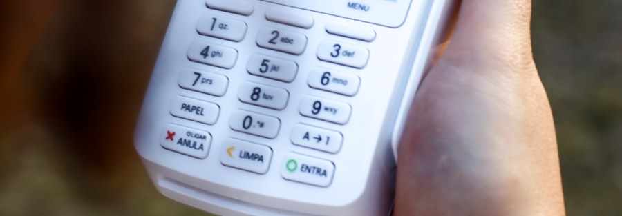 Mano sosteniendo una terminal de pago electrónico