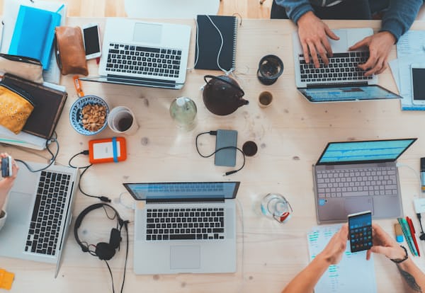 Vista cenital de un equipo trabajando con laptops y dispositivos