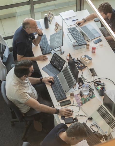 Equipo de trabajo con laptops organizando procesos en una mesa
